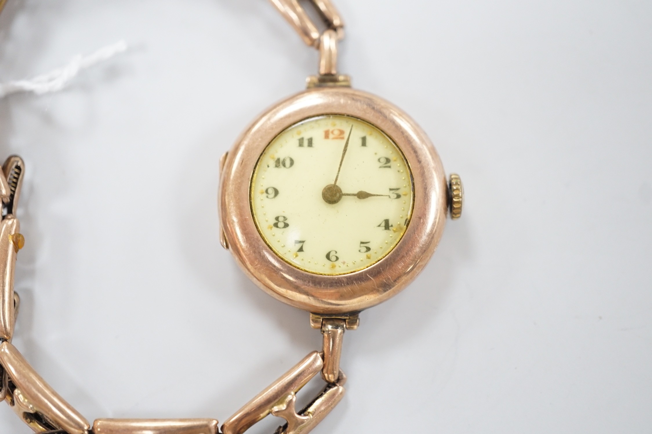 An early 20th century 9ct gold Rolex manual wind wrist watch, with Arabic dial, case diameter 27mm, on an expanding yellow metal bracelet, gross weight 22.1 grams.